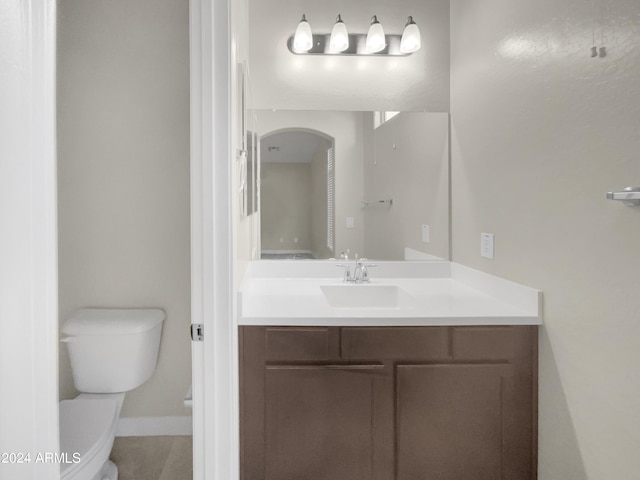 bathroom featuring tile patterned flooring, vanity, and toilet