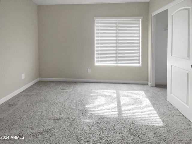 unfurnished room featuring light carpet