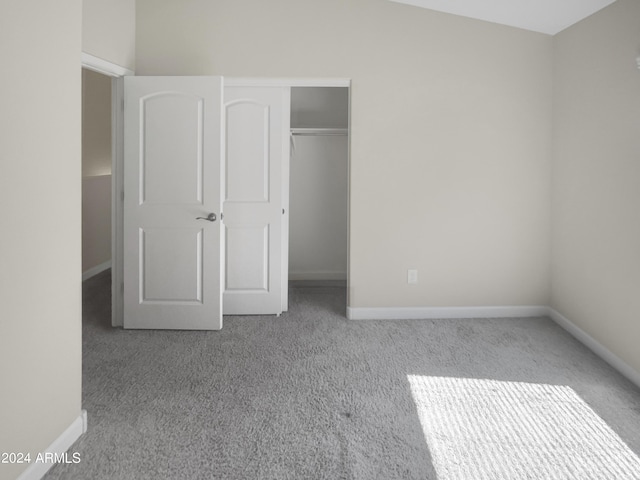 unfurnished bedroom with light carpet and a closet