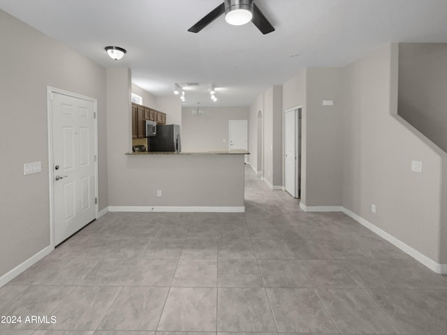 unfurnished living room with ceiling fan and light tile patterned floors