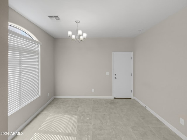 tiled empty room with a chandelier