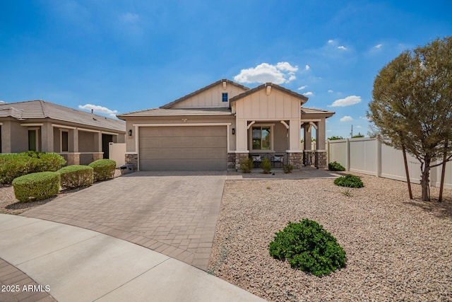 6550 S 24th Pl, Phoenix, AZ 85042 - craftsman-style house featuring stone siding, decorative driveway, a garage, covered porch, and board and batten siding