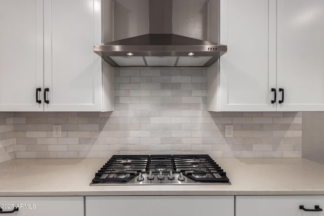 6550 S 24th Pl, Phoenix, AZ 85042 - kitchen featuring wall chimney range hood, stainless steel gas stovetop, white cabinets, decorative backsplash, and light stone countertops