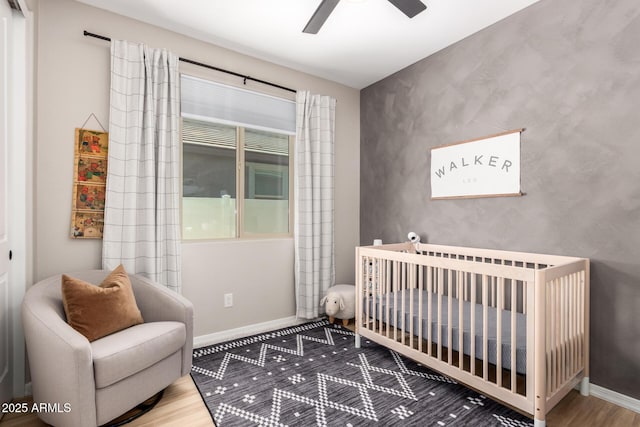 6550 S 24th Pl, Phoenix, AZ 85042 - bedroom featuring wood finished floors, a nursery area, baseboards, and a ceiling fan