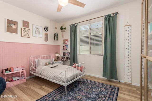 6550 S 24th Pl, Phoenix, AZ 85042 - bedroom featuring wood finished floors, a wainscoted wall, and ceiling fan