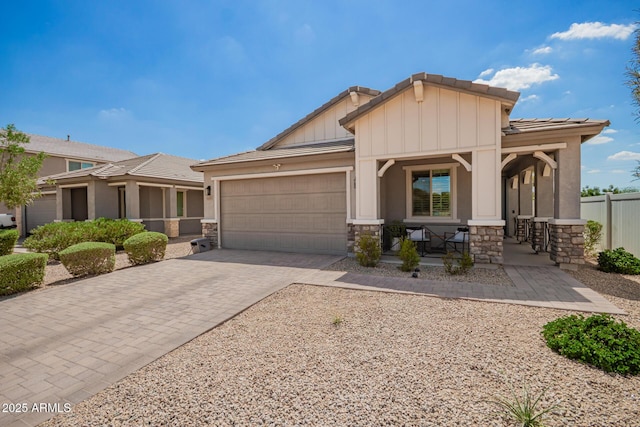 6550 S 24th Pl, Phoenix, AZ 85042 - view of front facade featuring covered porch, stone siding, a tiled roof, and an attached garage