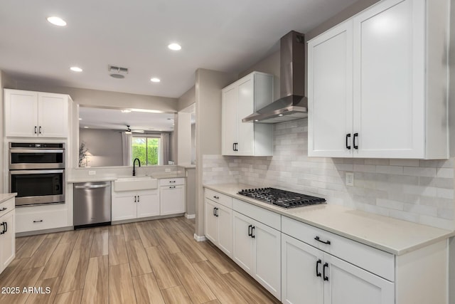 6550 S 24th Pl, Phoenix, AZ 85042 - kitchen featuring stainless steel appliances, wall chimney range hood, a sink, light countertops, and recessed lighting
