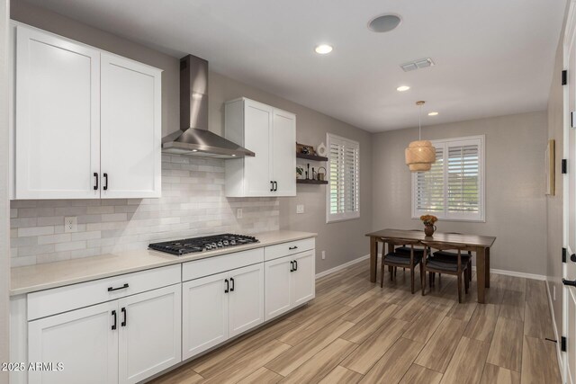6550 S 24th Pl, Phoenix, AZ 85042 - kitchen featuring wall chimney range hood, baseboards, tasteful backsplash, white cabinets, and recessed lighting