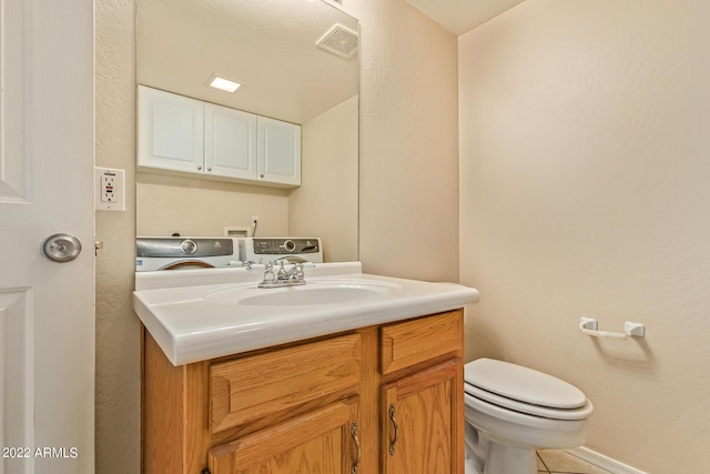 bathroom with tile patterned flooring, vanity, separate washer and dryer, and toilet