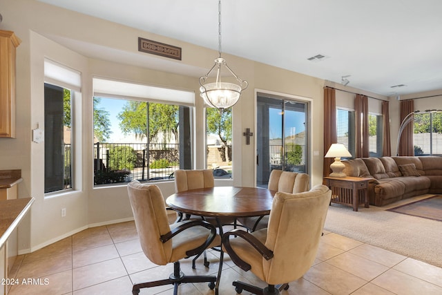 dining room with an inviting chandelier, a healthy amount of sunlight, and light tile patterned flooring