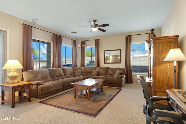 carpeted living room with ceiling fan and plenty of natural light