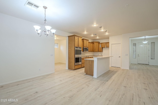 kitchen with light wood finished floors, visible vents, light countertops, brown cabinetry, and stainless steel appliances