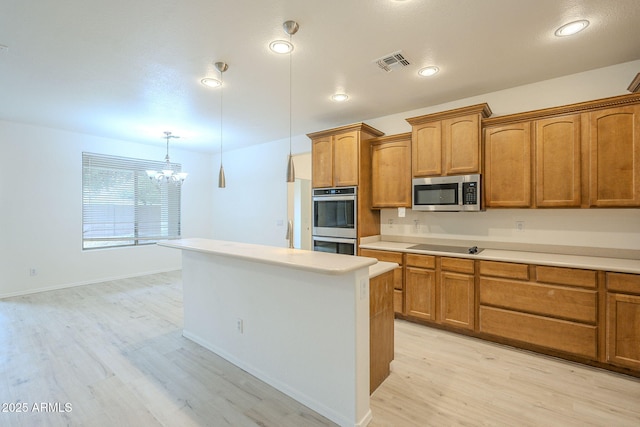 kitchen with brown cabinetry, visible vents, light wood-style flooring, light countertops, and appliances with stainless steel finishes