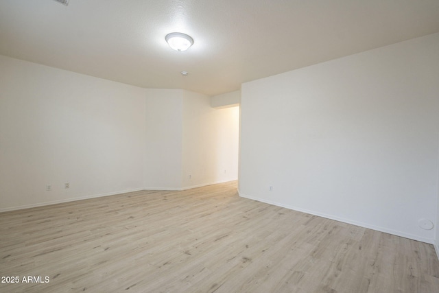 spare room with light wood-style flooring and baseboards