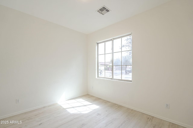 unfurnished room featuring light wood-style flooring, baseboards, and visible vents