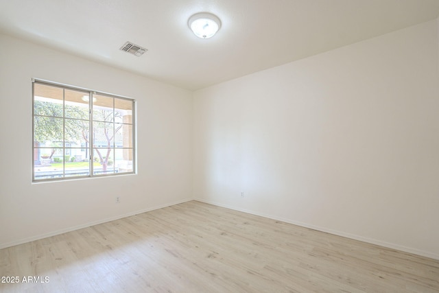 unfurnished room with visible vents, baseboards, and wood finished floors