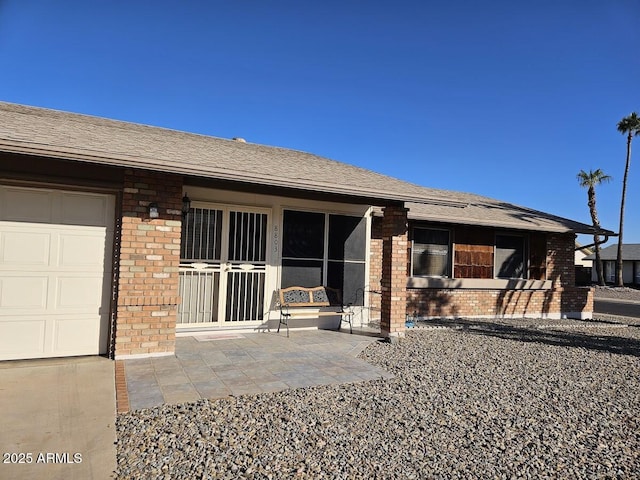 rear view of property featuring a patio area and a garage