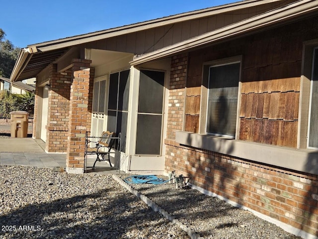 view of exterior entry with a patio area