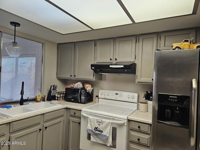 kitchen featuring sink, white range with electric stovetop, gray cabinets, pendant lighting, and stainless steel fridge