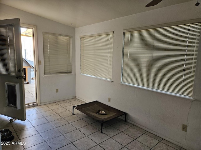 interior space featuring light tile patterned flooring, ceiling fan, and vaulted ceiling