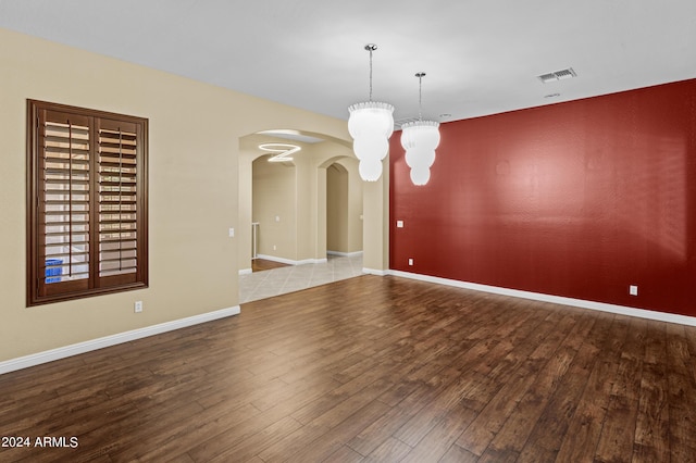 kitchen featuring decorative backsplash, stainless steel appliances, recessed lighting, arched walkways, and wall chimney range hood