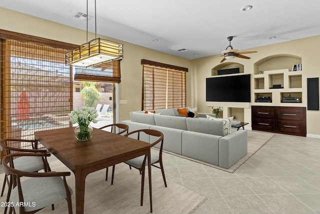 dining area with baseboards, built in shelves, light tile patterned flooring, visible vents, and ceiling fan