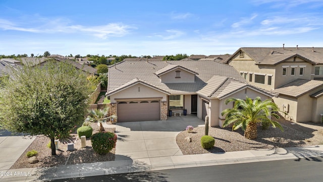 view of front facade with stone siding, concrete driveway, stucco siding, a tiled roof, and a garage