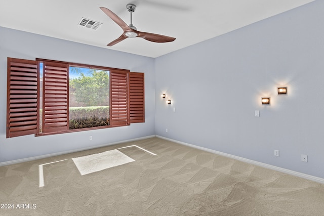 empty room featuring ceiling fan and light colored carpet