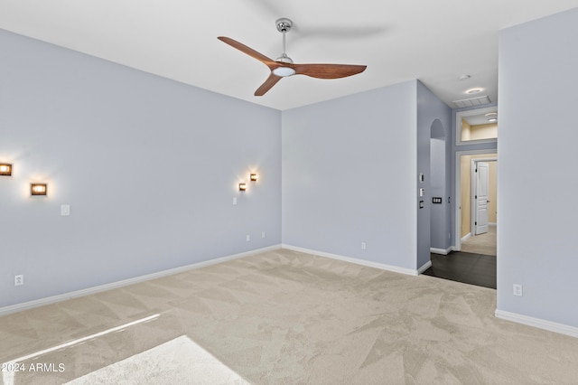 carpeted spare room with ceiling fan