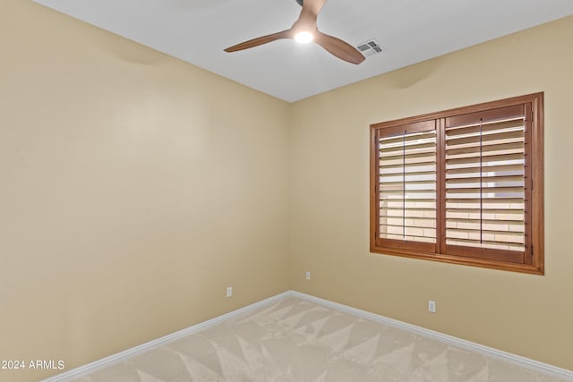 spare room with light carpet, baseboards, ceiling fan, and visible vents