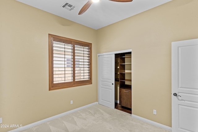 unfurnished bedroom featuring carpet, baseboards, ceiling fan, visible vents, and a closet