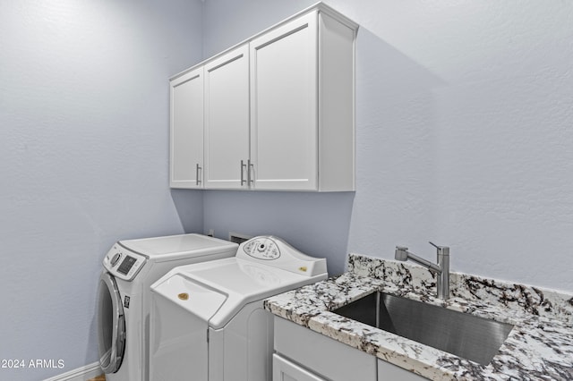 laundry area featuring sink, separate washer and dryer, and cabinets