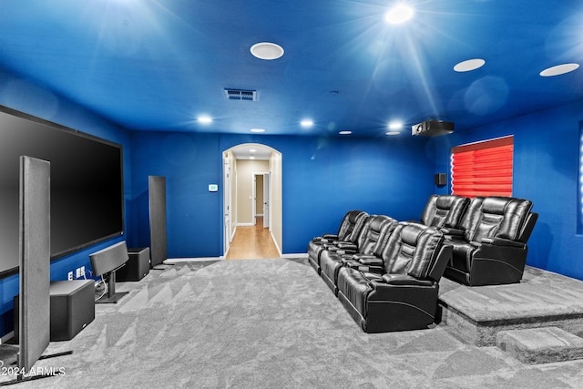 home theater featuring arched walkways, carpet, baseboards, and visible vents