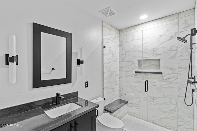 bathroom featuring toilet, a shower with door, and vanity