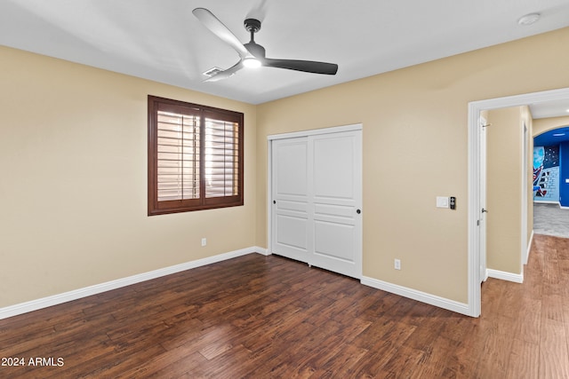 unfurnished bedroom featuring a closet, ceiling fan, and dark hardwood / wood-style floors