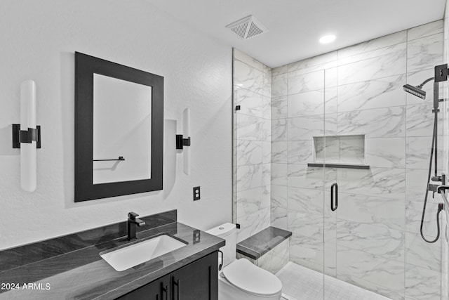 full bath featuring vanity, toilet, a textured wall, a stall shower, and visible vents