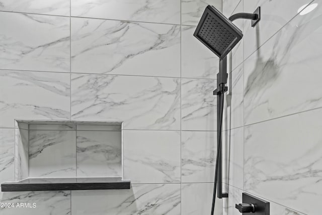 interior details featuring tiled shower