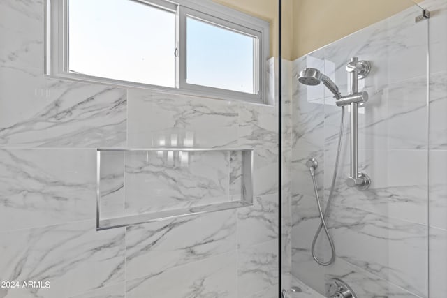 full bathroom featuring a marble finish shower