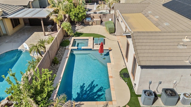 pool featuring a patio, a fenced backyard, and an in ground hot tub