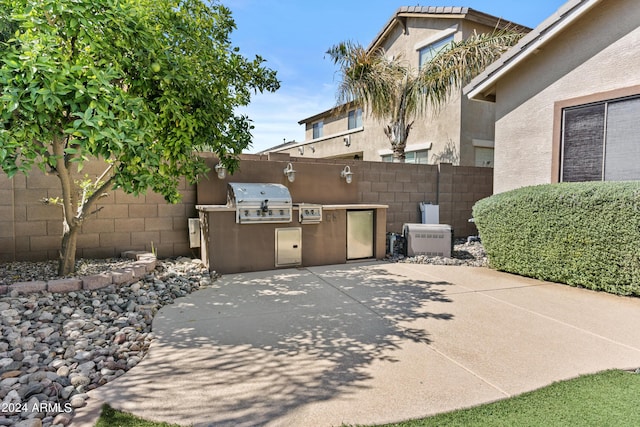 view of patio / terrace featuring grilling area, an outdoor kitchen, and fence