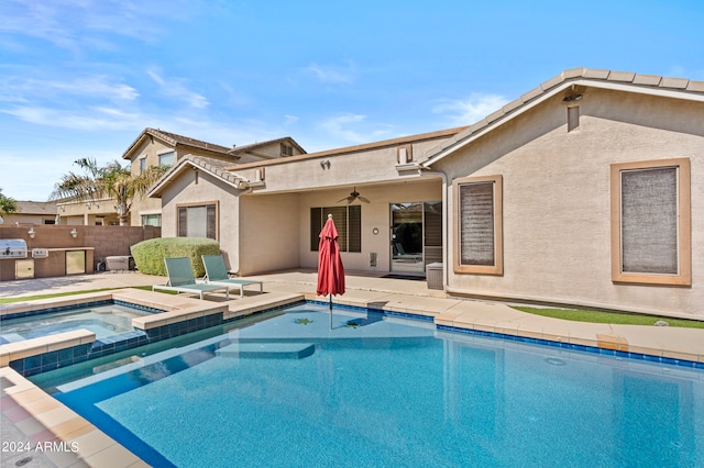 rear view of house featuring a pool with hot tub, a patio, and ceiling fan