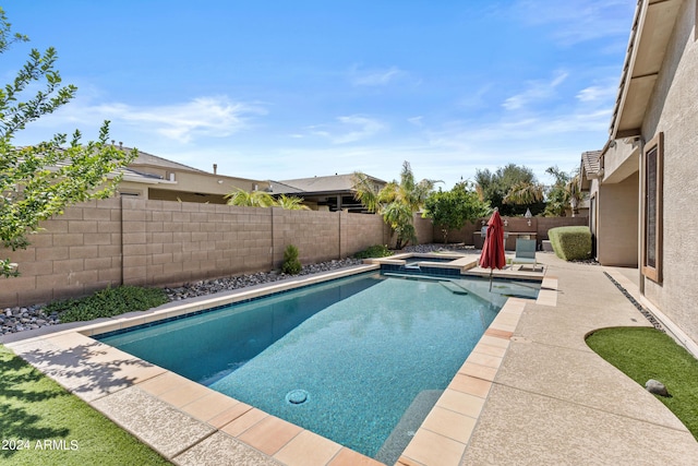 view of swimming pool featuring a fenced backyard, a pool with connected hot tub, and a patio