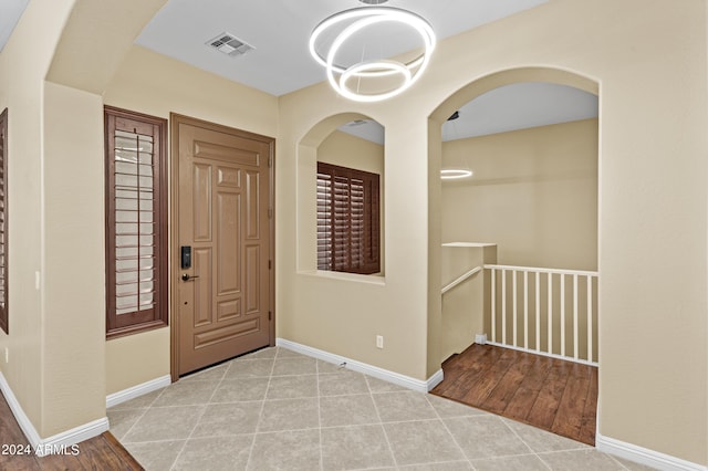 tiled entrance foyer featuring baseboards and visible vents