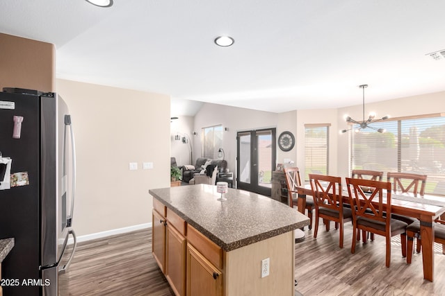 8637 W Kathleen Rd, Peoria, AZ 85382 - kitchen with a kitchen island, dark countertops, wood finished floors, freestanding refrigerator, and an inviting chandelier