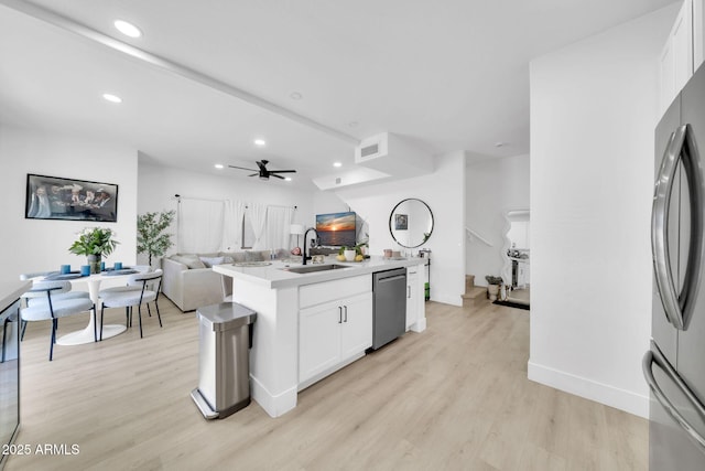 3034 N 39th St Unit 12, Phoenix, AZ 85018 - kitchen with appliances with stainless steel finishes, open floor plan, light wood-style floors, ceiling fan, and white cabinetry