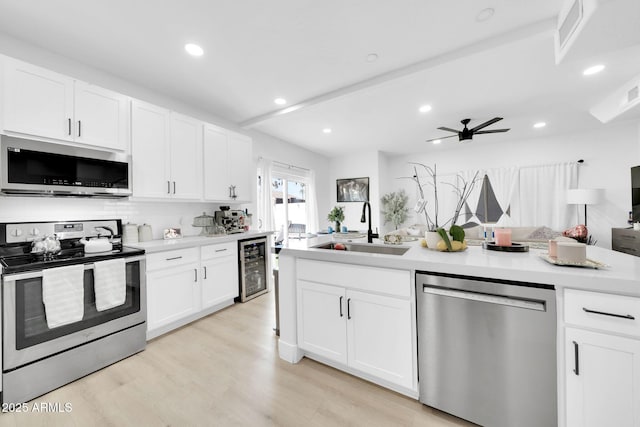 3034 N 39th St Unit 12, Phoenix, AZ 85018 - kitchen featuring stainless steel appliances, light countertops, wine cooler, white cabinets, and recessed lighting