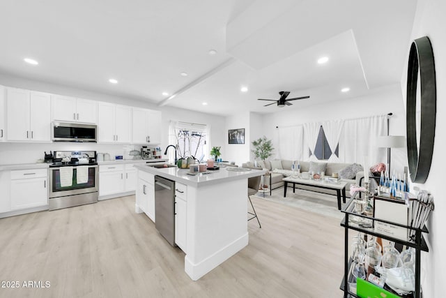 3034 N 39th St Unit 12, Phoenix, AZ 85018 - kitchen with appliances with stainless steel finishes, light wood-style flooring, open floor plan, white cabinetry, and recessed lighting