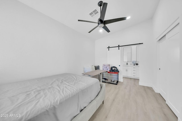 3034 N 39th St Unit 12, Phoenix, AZ 85018 - bedroom featuring light wood-type flooring, lofted ceiling, a barn door, and ceiling fan