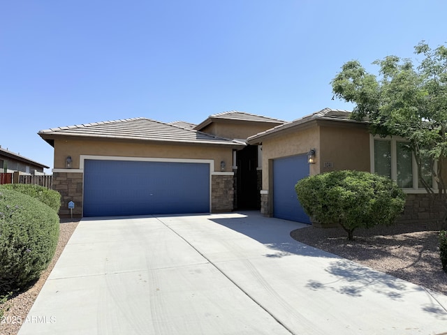 1241 E Palo Verde Dr, Casa Grande, AZ 85122 - view of front of home with stone siding, a garage, driveway, stucco siding, and a tiled roof