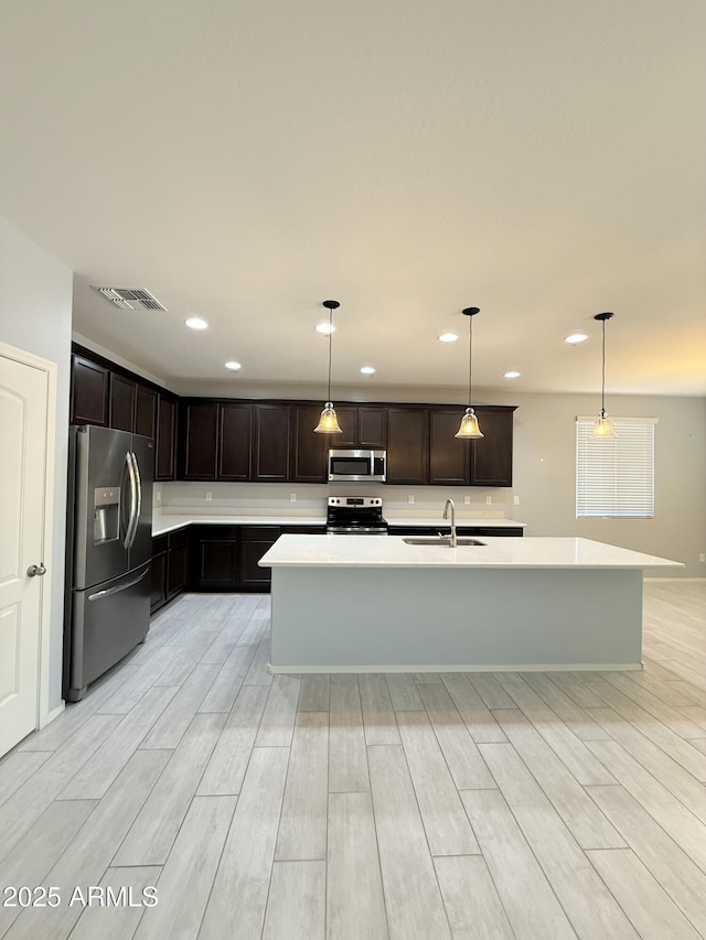 1241 E Palo Verde Dr, Casa Grande, AZ 85122 - kitchen featuring appliances with stainless steel finishes, light wood-type flooring, a sink, light countertops, and recessed lighting